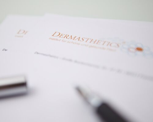 A high quality ballpoint pen on paper of the Institute of beautiful and healthy skin. The logo of Dermasthetics is plain to see. The background is washed out.