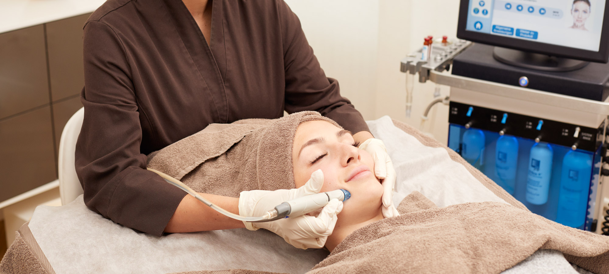 Beim Vampire Treatment wird mit einem Lifting-Pen das PRP unter die Haut eingebracht. Die Patientin liegt während einer Plasma Lifting Behandlung entspannt in saubere Handtücher gehüllt auf einer Behandlungsliege im Frankfurter Kosmetikinstitut.